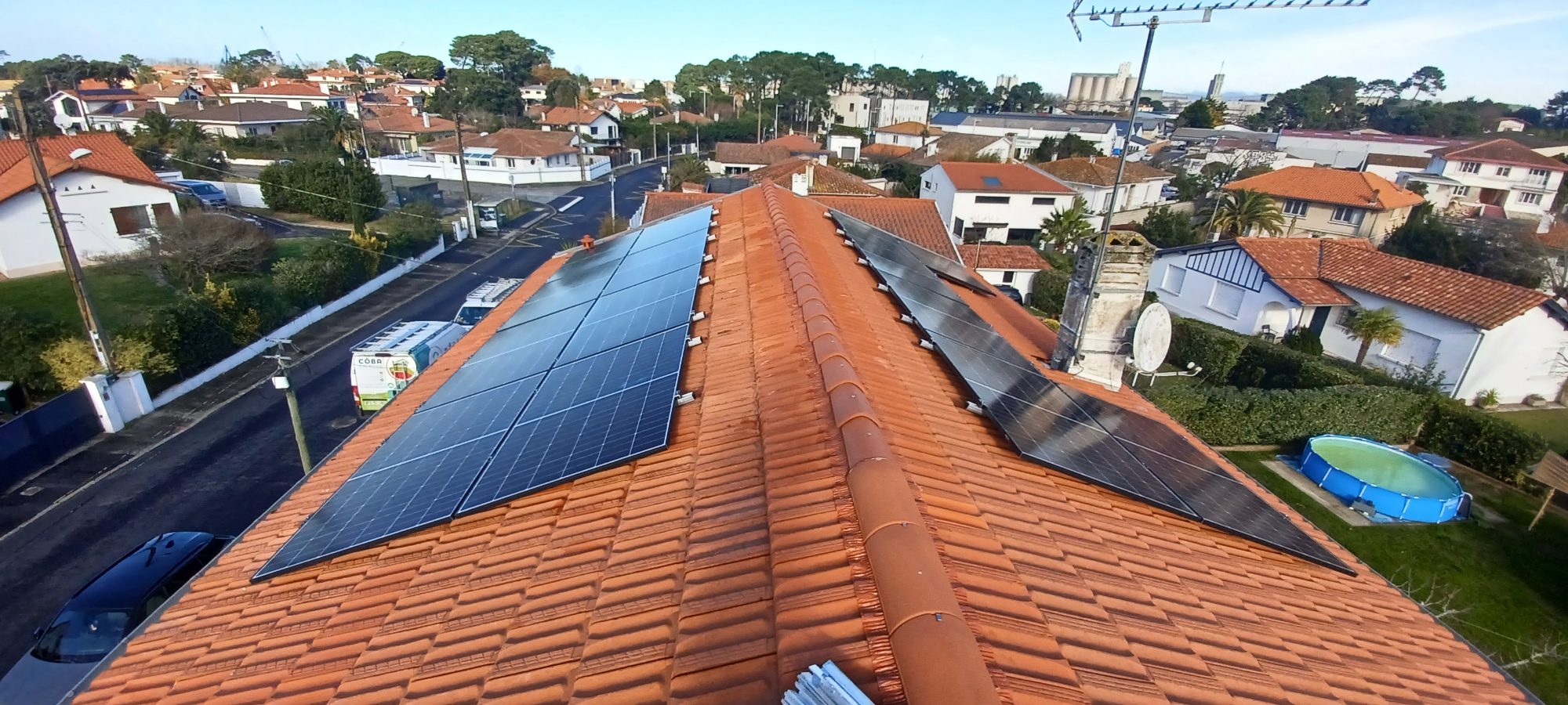 Panneaux photovoltaïques sur une toiture en tuiles avec vue sur le quartier