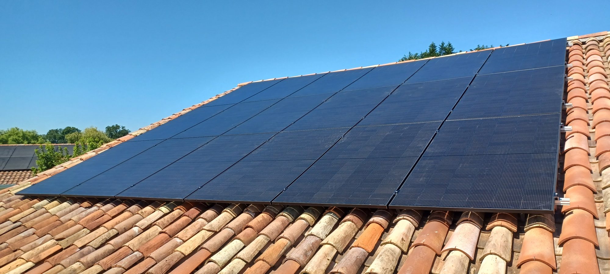 Panneaux solaires sur une toiture en tuiles canal sous un ciel bleu